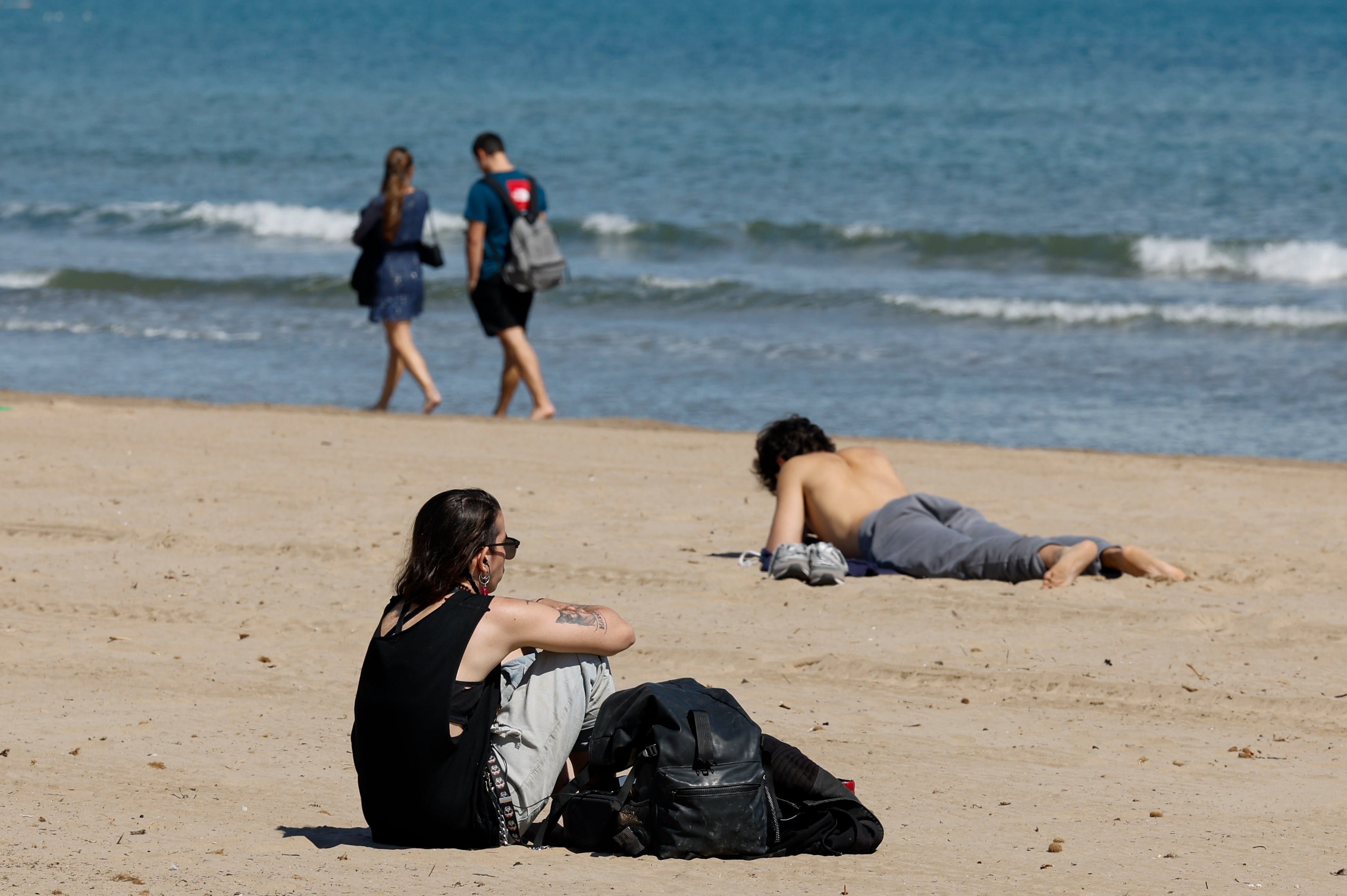 Varias personas disfrutan del buen tiempo en la playa de la Malvarrosa (Valencia) este lunes. 